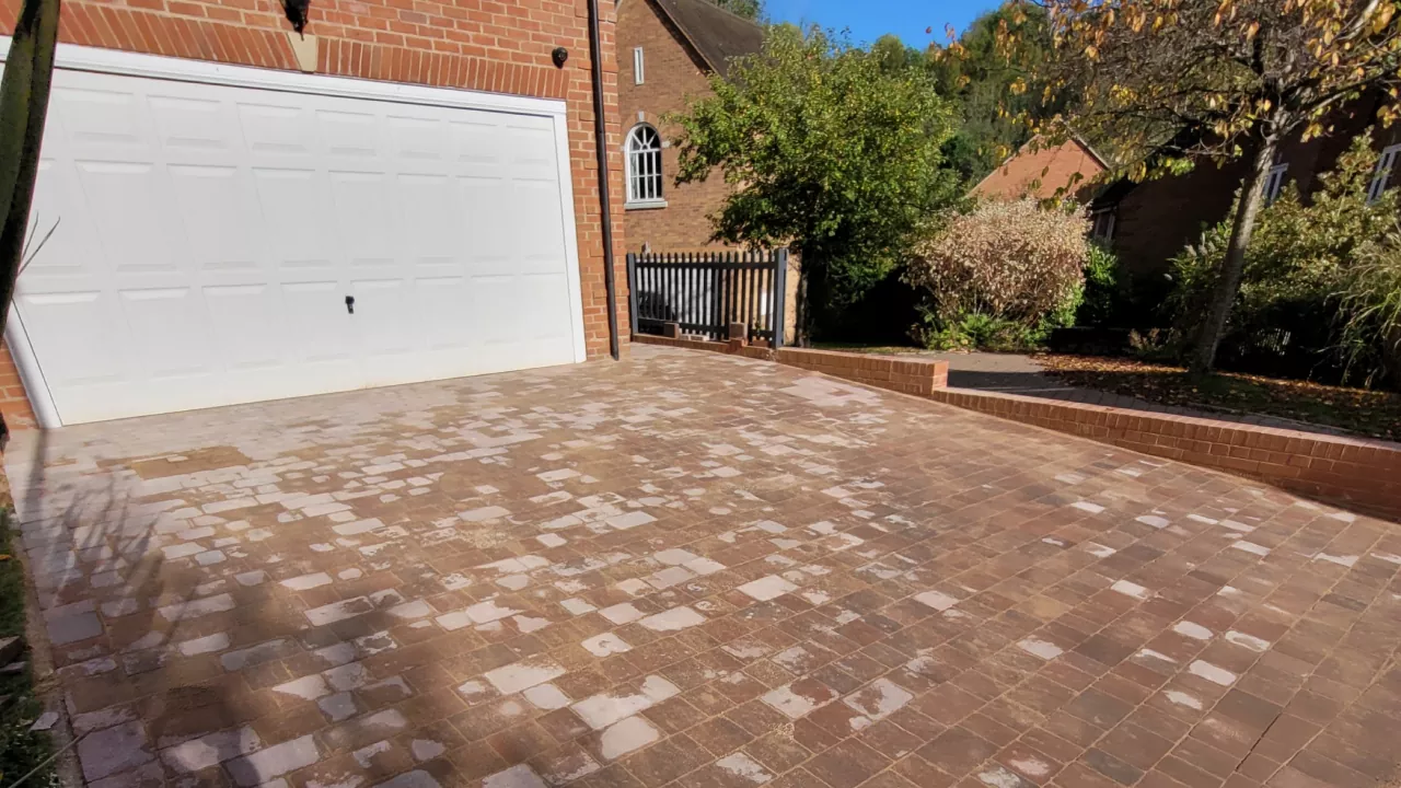 A large open private drive laid to block with a bright white garage