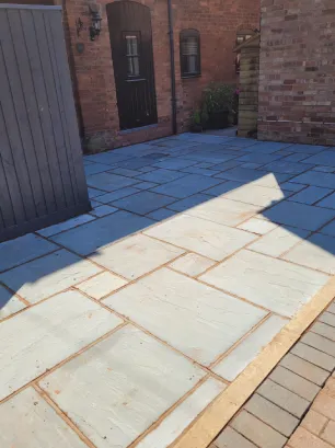 A grey slate slabbed patio to the side of a house