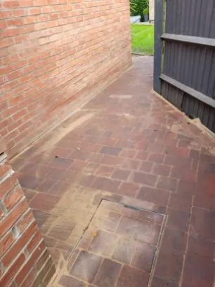 A red blocked pavement to the side of a house