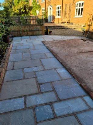 A grey slabbed walkway to the rear of a property